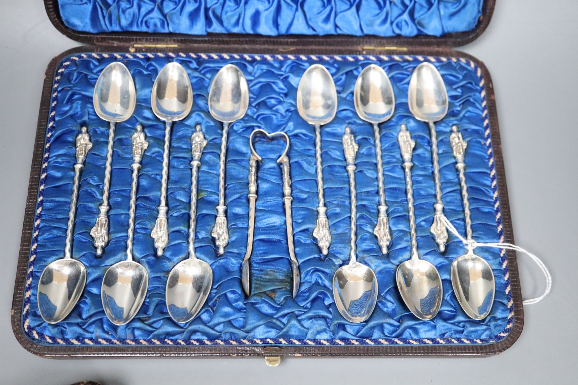 Twelve Victorian silver Apostle coffee spoons and sugar tongs, and three sets of six silver bean end coffee spoons, all cased